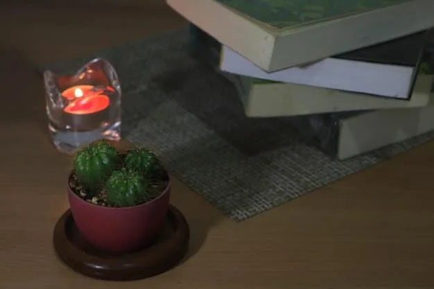 A close-up of a bedside table with a book, a glass of water, and a small plant, illuminated by a soft nightlight.