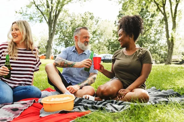 A group of diverse friends laughing and talking while having a picnic in a sunny park, highlighting connection and joy.