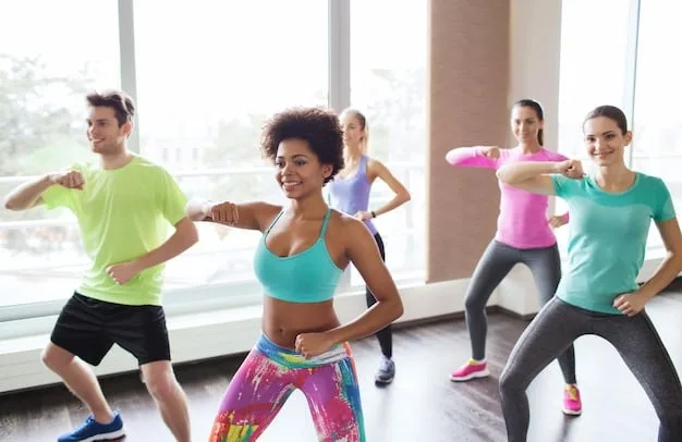 A diverse group of people is joyfully participating in a Zumba class in a brightly lit studio, showcasing the fun and social aspects of group fitness.