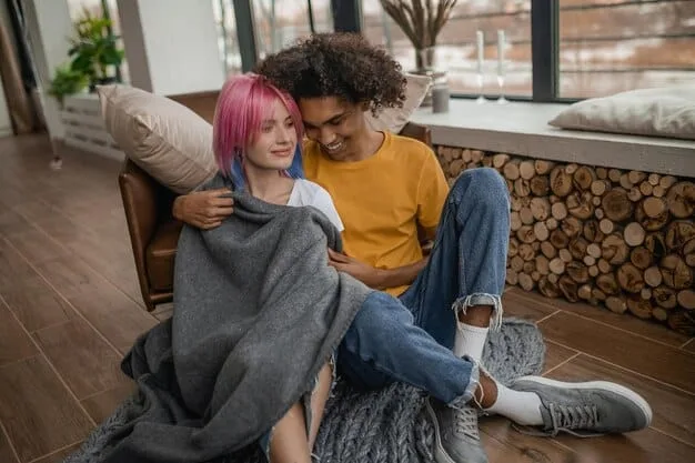 Two people sitting on a couch, deep in conversation, with one person comforting the other with a hand on their shoulder. The setting is a cozy living room, emphasizing trust and empathy.