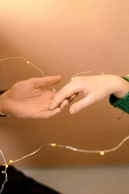 A close-up of two hands gently touching, with a soft light emphasizing the connection. A blurred background suggests a bustling city scene, highlighting the importance of maintaining personal space even amidst external chaos.