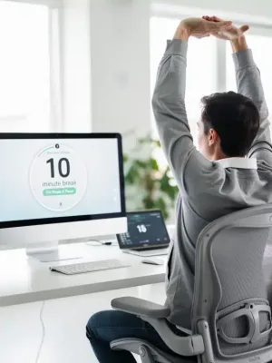 Person taking a brief, refreshing micro-break at their desk during a workday.