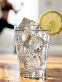 Clear glass of water with lemon slice, symbolizing healthy hydration