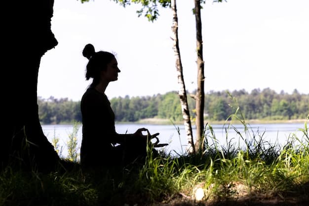A serene image of a person meditating outdoors with their eyes closed, surrounded by nature. The focus is on their relaxed posture and controlled breathing, emphasizing the calming effect of the practice.
