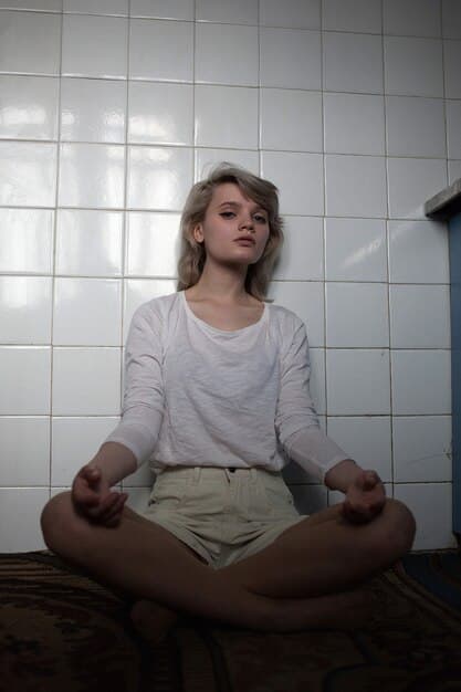 A person sitting alone in a quiet room, eyes closed, meditating. Soft, natural light illuminates their face, showing a sense of peace despite the surrounding circumstances.