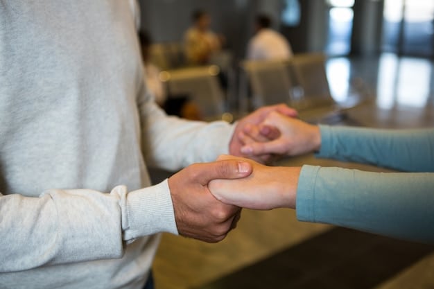 A close-up shot of two hands clasped together during a meeting, symbolizing mutual support and understanding. The background is blurred, focusing attention on the gesture of connection and empathy.