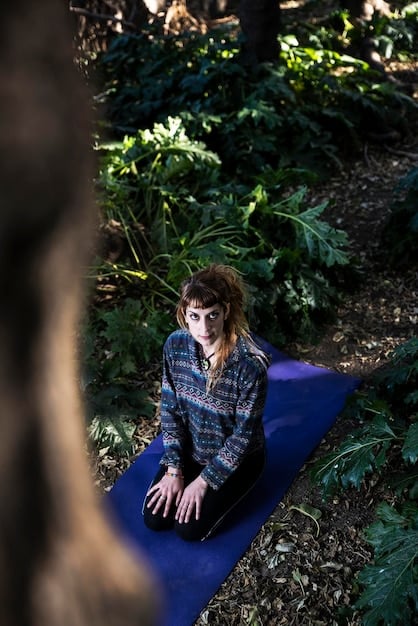 A person practicing yoga outdoors in a serene environment. They are focused and at peace.