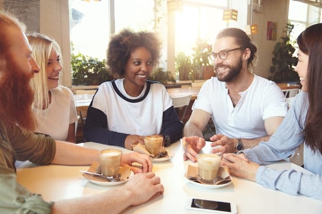 A group of friends laughing, symbolizing positive relationships and social support. They are sitting at a table in a cafe, enjoying each other's company.