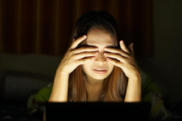 A close-up shot of tired, strained eyes looking at a bright computer screen. The room is dimly lit, emphasizing the screen's glare.
