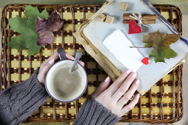 A person's hands writing in a gratitude journal, surrounded by small, meaningful objects like a teacup, a flower, and a photo, symbolizing gratitude and mindfulness.