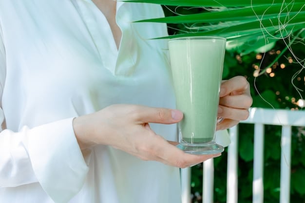 A close-up shot of a green smoothie being poured into a tall glass, with various fresh fruits and vegetables (spinach, kale, banana, berries) artfully arranged around the glass to showcase the ingredients. The smoothie looks vibrant and appetizing.