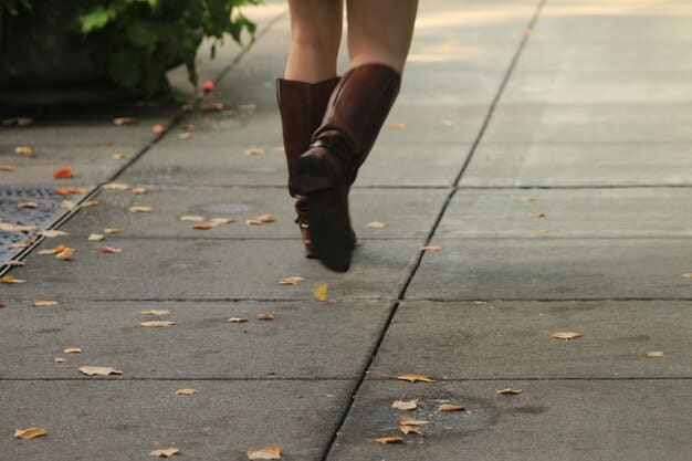 A close-up of a person's legs and feet as they walk briskly on a paved road. The focus is on the motion and the ground beneath, showcasing the physical effort involved in walking. The scene suggests active movement and outdoor exercise.